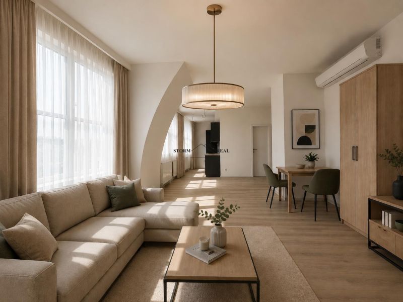Wohnzimmer mit Sofa, Tisch und Holzboden in einer Einzimmerwohnung.