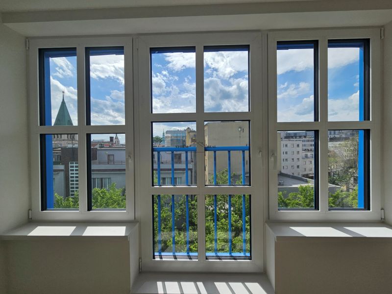 Blick aus einer Einzimmerwohnung auf die Skyline von Bratislava durch große Fenster.