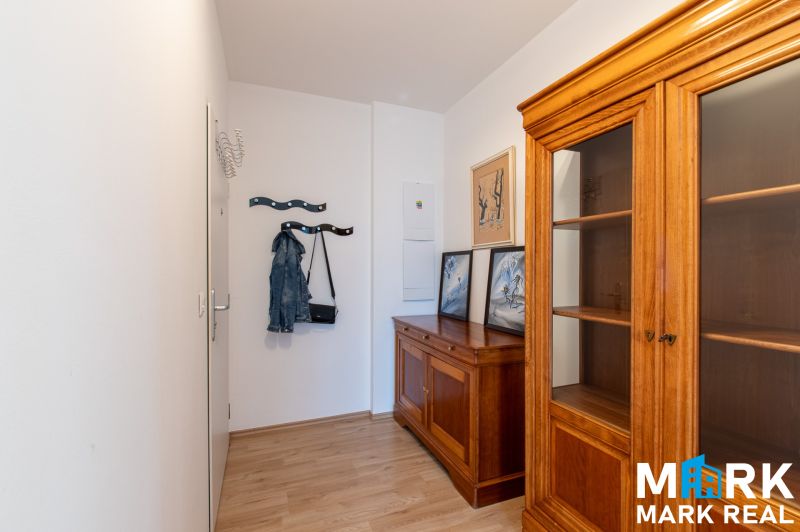 Innenraum einer 2-Zimmer-Wohnung mit Holzmöbeln und einem Boden in Holzoptik.