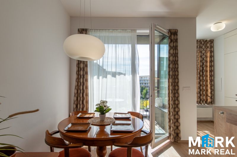 Essbereich mit rundem Tisch und Stühlen in einer Zweizimmerwohnung.