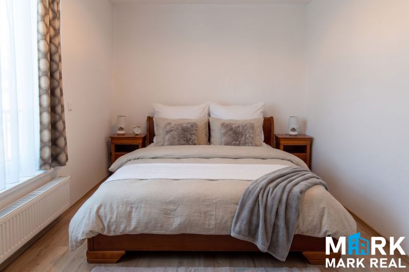 Schlafzimmer mit Bett und Holzmöbeln in einer 2-Zimmer-Wohnung, Boden mit Holzdekor.