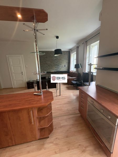 Die Küche einer 2-Zimmer-Wohnung mit einem Holzboden und einer modernen Theke.