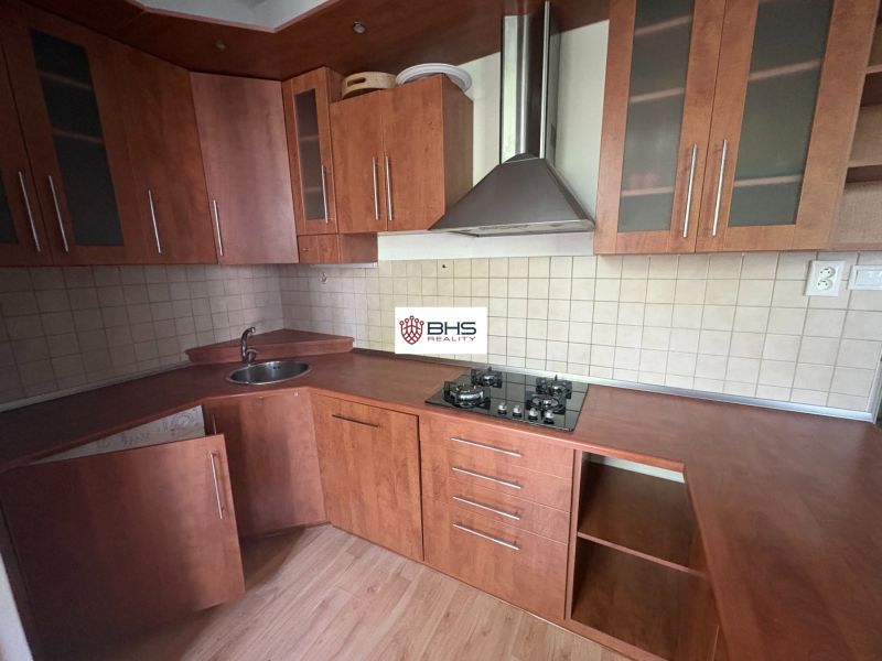 Küche in einer 2-Zimmer-Wohnung mit Holzboden und brauner Küchenzeile.