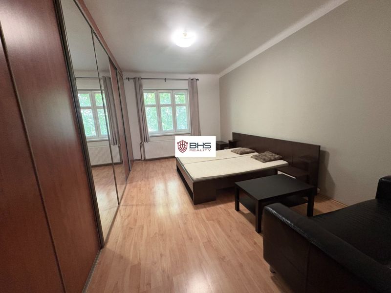 Geräumiges Schlafzimmer in einer 2-Zimmer-Wohnung mit Holzboden und Einbauschränken.