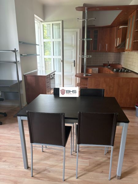 2-Zimmer-Wohnung mit Küche und Esszimmer, Holzboden mit Holzdekor, Möbel aus dunklem Holz.