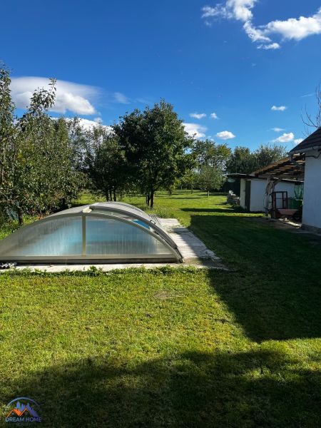 Ein Einfamilienhaus im Čalovecká-Garten mit einem Pool unter einer gewölbten Abdeckung und einer Rasenfläche.