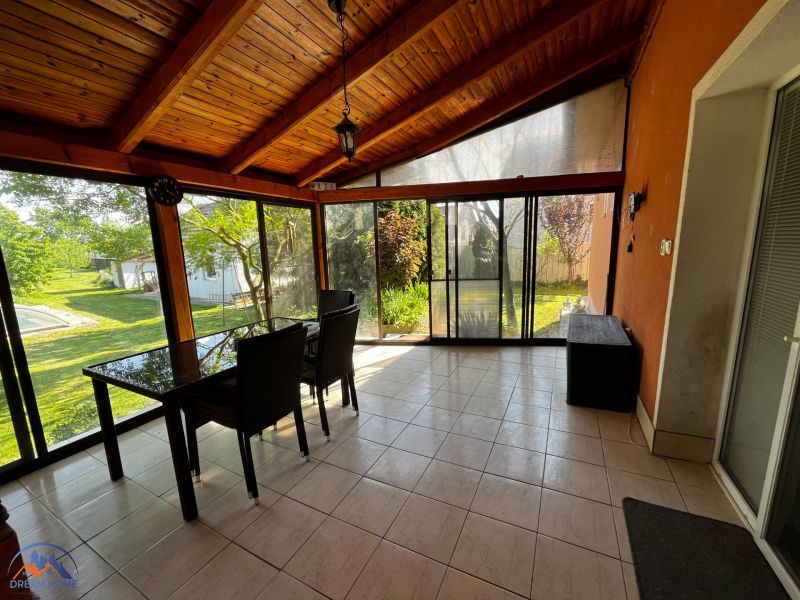 Eine verglaste Terrasse in einem Einfamilienhaus mit Blick auf den Garten.