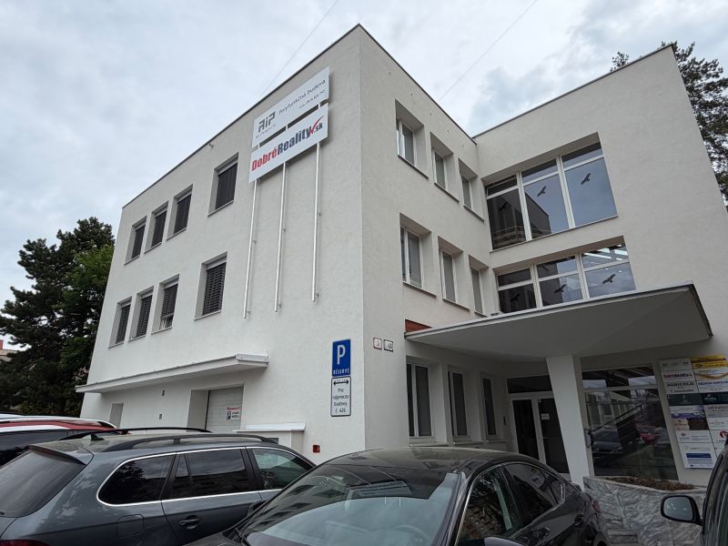 Ein Bürogebäude in der Dlhá-Straße in Prievidza mit geparkten Autos.