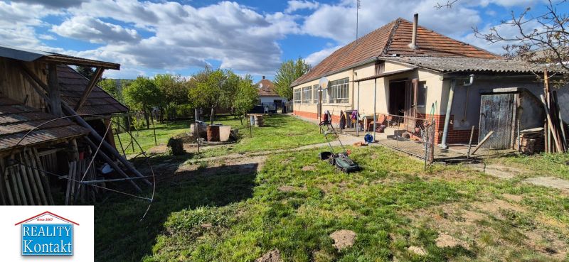 Einfamilienhaus in Dedinka mit Garten, Rasenfläche und Geräteschuppen.
