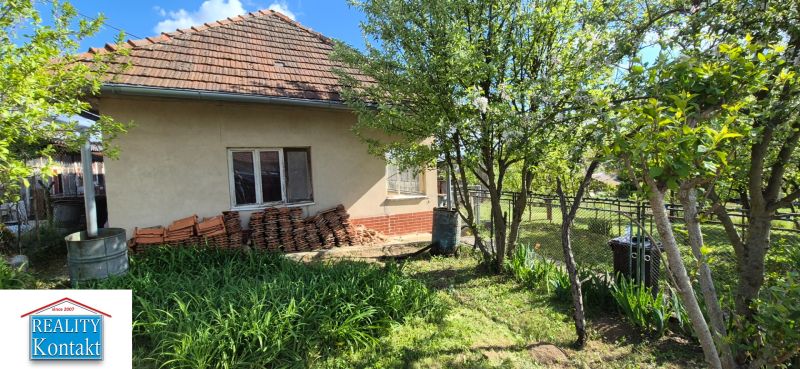 Ein Einfamilienhaus in Dedinka mit Vorgarten und Blumenbeet.