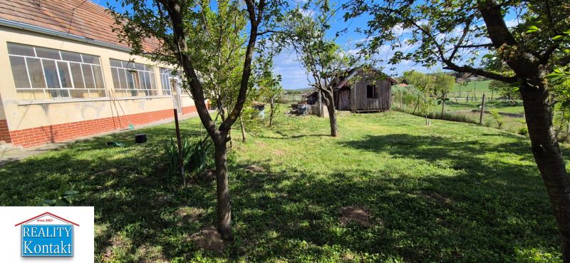 Ein Einfamilienhaus in Dedinka mit einer verglasten Veranda, einem Garten und einem Holzbau im Hof.