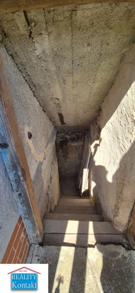 Ein düsterer Treppenhausflur in einem Einfamilienhaus mit einer beschatteten Wand.