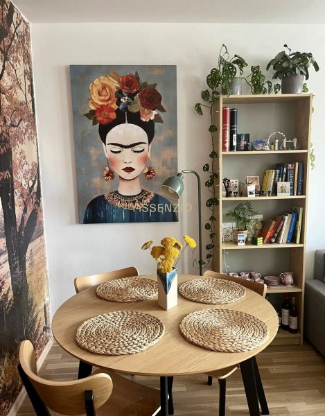 Esszimmer in einer 2-Zimmer-Wohnung mit einem Bild, einem Holztisch und dekorativen Accessoires.