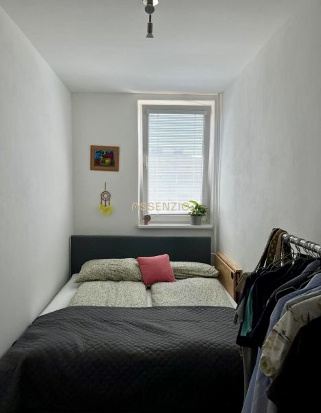Gemütliches Schlafzimmer mit Bett, Bild und Kleiderschrank in einer 2-Zimmer-Wohnung.