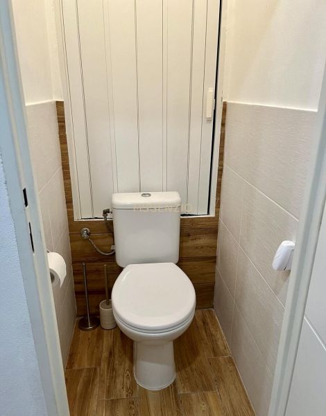 Toilette in einer 2-Zimmer-Wohnung mit Holzboden.