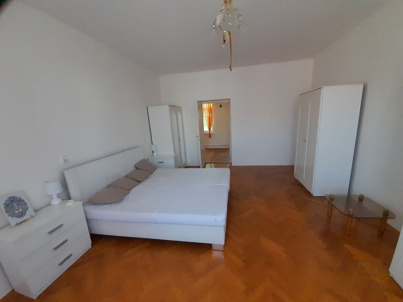 Ein Schlafzimmer in einer 4-Zimmer-Wohnung mit hellen Möbeln und einem Boden in Holzoptik.