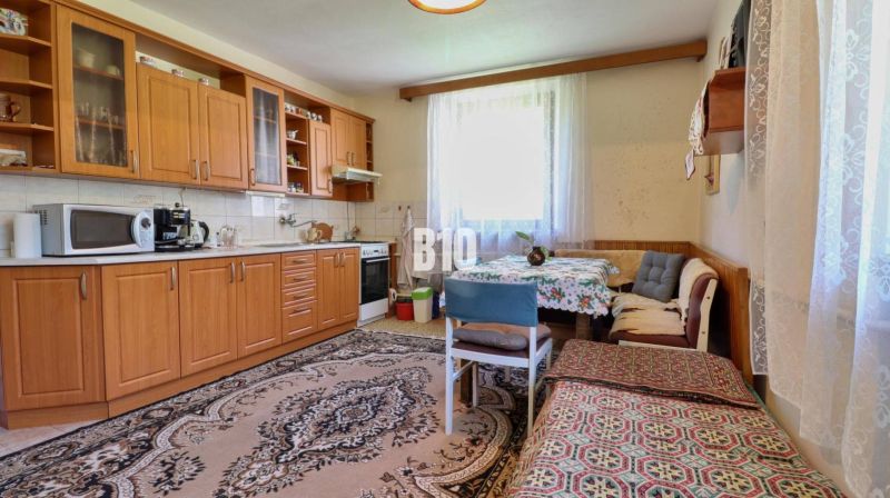 Küche in einem Einfamilienhaus mit Holzmöbeln und Essecke.