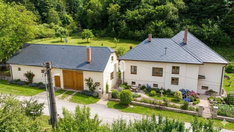 Einfamilienhaus in Belá-Dulice mit gepflegtem Garten und umliegendem Grün.