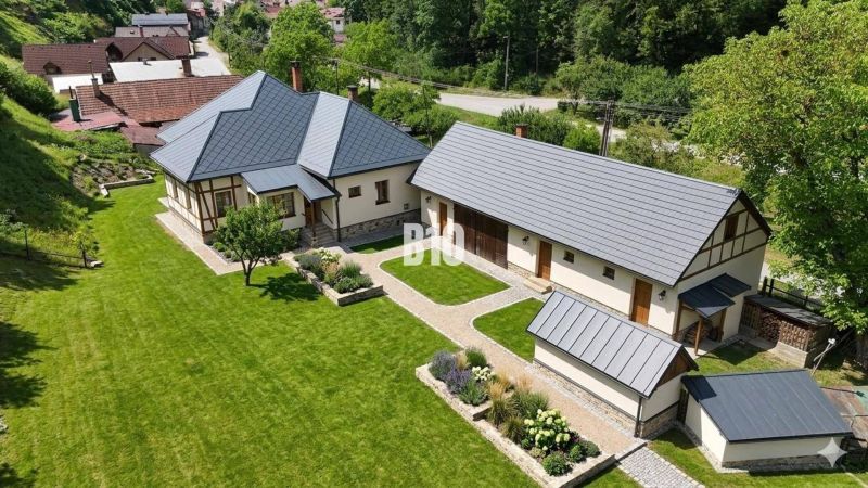 Ein Einfamilienhaus in Belá-Dulice mit großem Garten und gepflegtem Rasen.