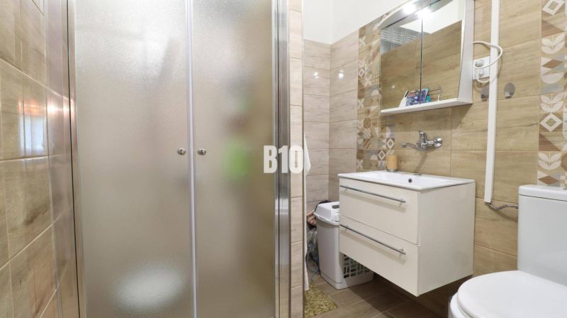 Badezimmer in einem Einfamilienhaus mit Waschbecken und Duschkabine.