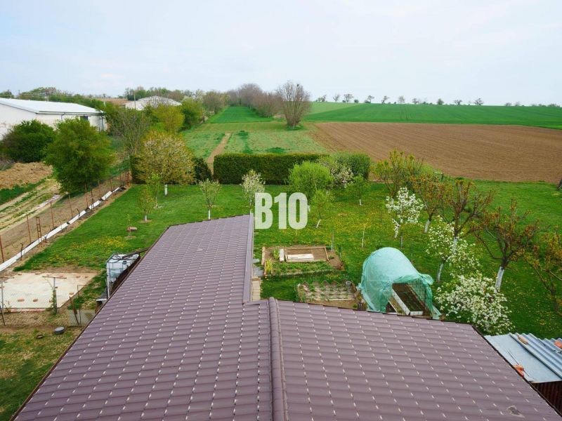 Ein Einfamilienhaus in Lukáčovce mit einem weitläufigen Garten und umliegenden Feldern.