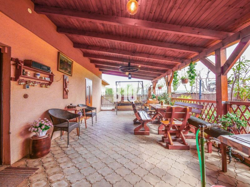 Die Terrasse des Einfamilienhauses in Lukáčovce mit Holzsitzgelegenheiten und Dekorationen.
