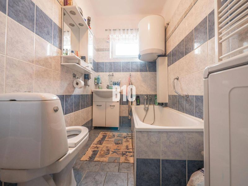 Ein Badezimmer in einem Einfamilienhaus mit einer Badewanne und blauen Fliesen.