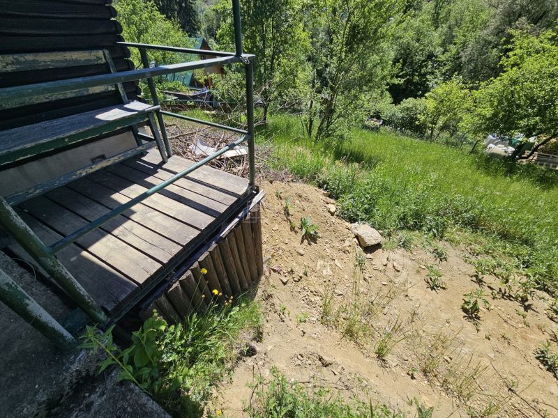 Eine Hütte in Budatín mit Terrasse und Blick auf das Grün und den Hang.
