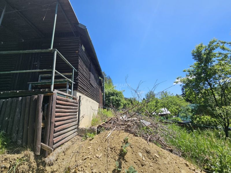 Eine Hütte in Budatín, umgeben von Natur und Grün, mit Holzelementen.