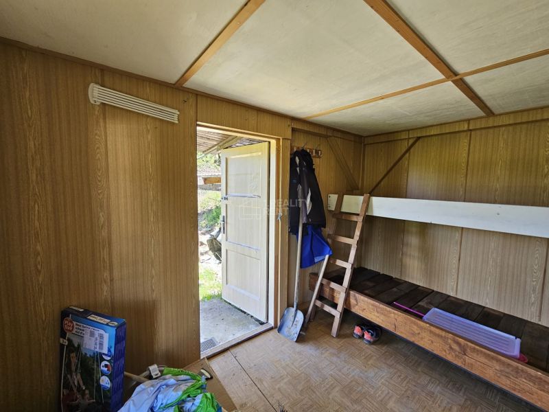 Ein Zimmer in einer Hütte mit einem Etagenbett und einem Boden in Holzoptik.