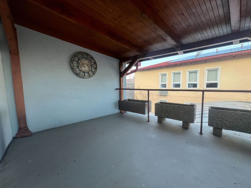 Überdachte Terrasse mit Uhren und Pflanzgefäßen in den Produktionsräumen.