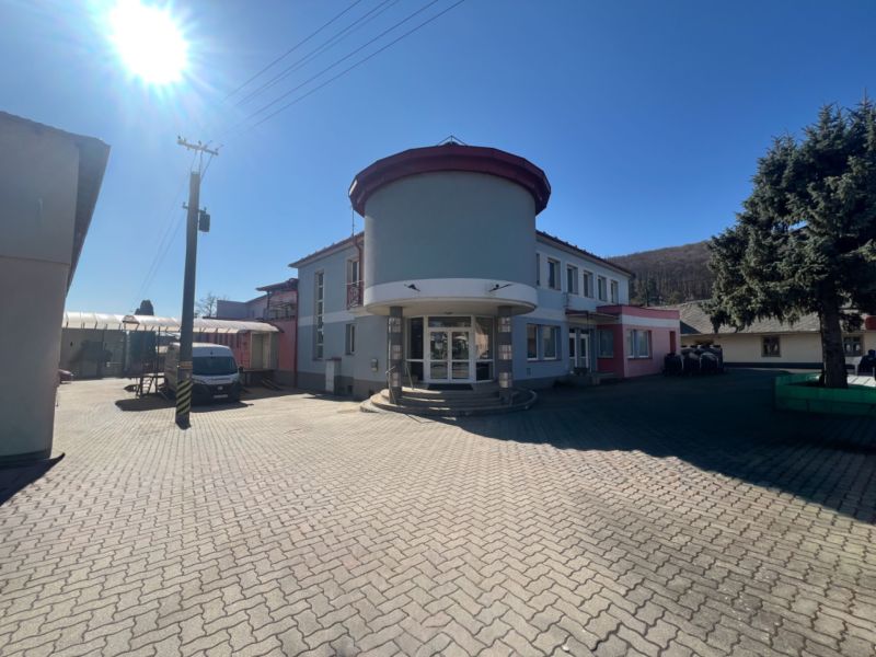 Produktionsräume in Kremnička, Banská Bystrica, umgeben von einem gepflasterten Hof und Bäumen.