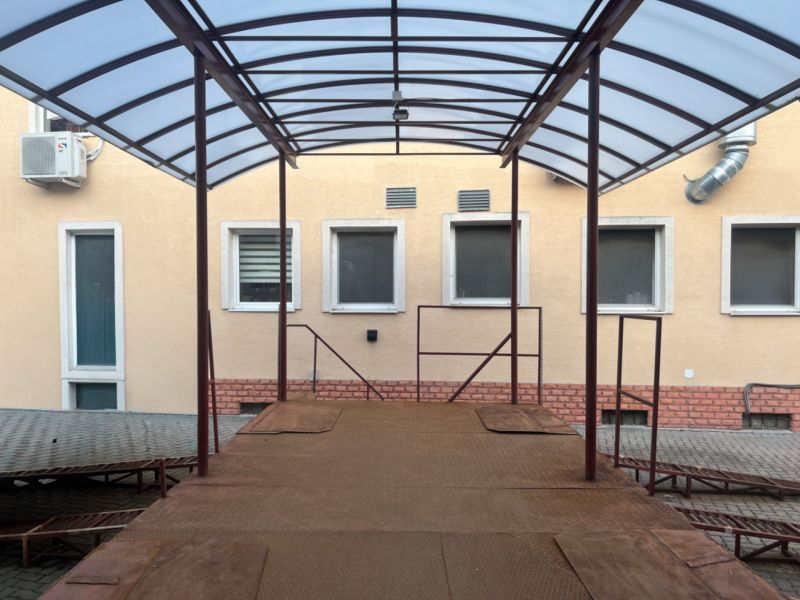 Ein Unterstand mit Metallkonstruktion bei einem Gebäude in Banská Bystrica, Lager und Hallen.