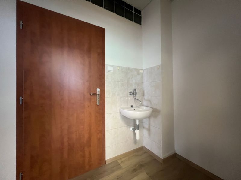 Büros mit Waschbecken, Türen und Boden in Holzoptik.