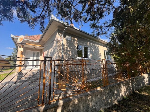 Ein Einfamilienhaus in Vrakúňa mit einem dekorativen Metallzaun und Bäumen im Hintergrund.
