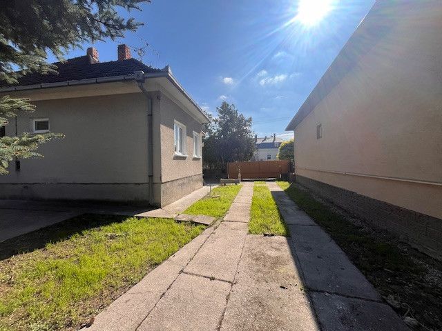 Ein Einfamilienhaus in Vrakúňa mit einem Betonweg und einer Rasenfläche.