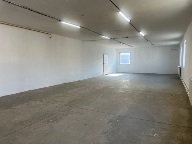 Ein geräumiges, leeres Interieur mit Betonboden und weißen Wänden in Lagerhäusern und Hallen.