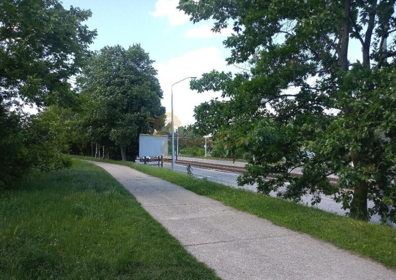 Ein Weg entlang der Eisenbahnstrecke, umgeben von Grün in Bratislava - Karlova Ves auf der Karloveská.