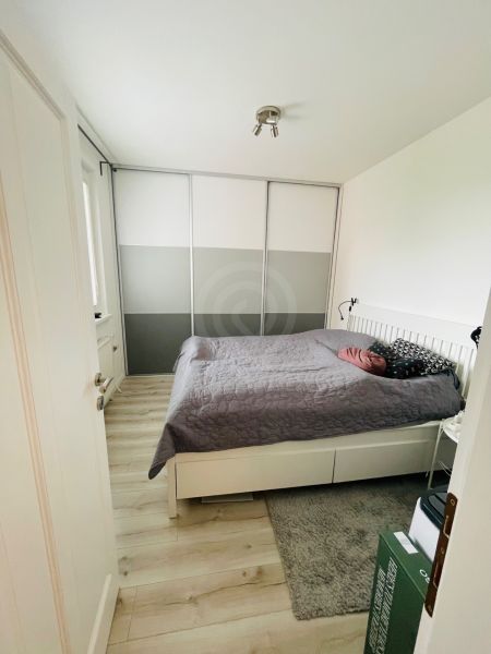 Schlafzimmer in einer 3-Zimmer-Wohnung mit Holzboden und einem großen Schrank.