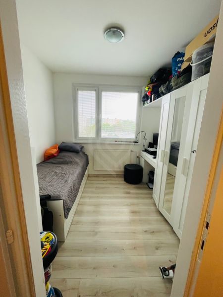 Kinderzimmer mit Schrank, Bett und Boden in Holzoptik, 3-Zimmer-Wohnung.