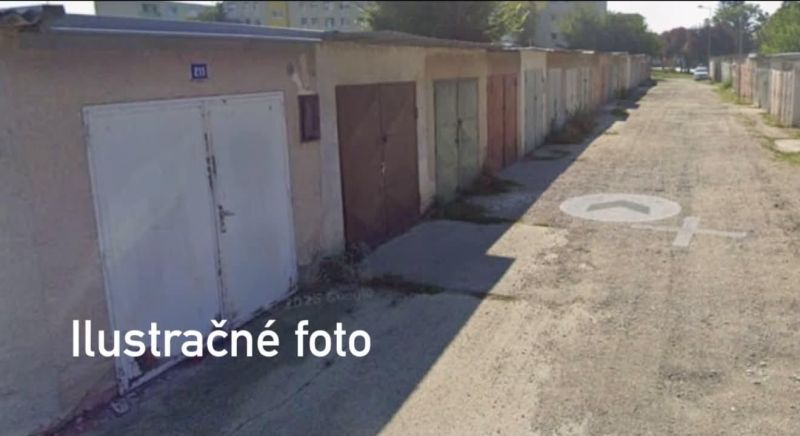 Eine Reihe von Garagen in Dunajská Streda mit unterschiedlich farbigen Türen auf einer befestigten Straße.