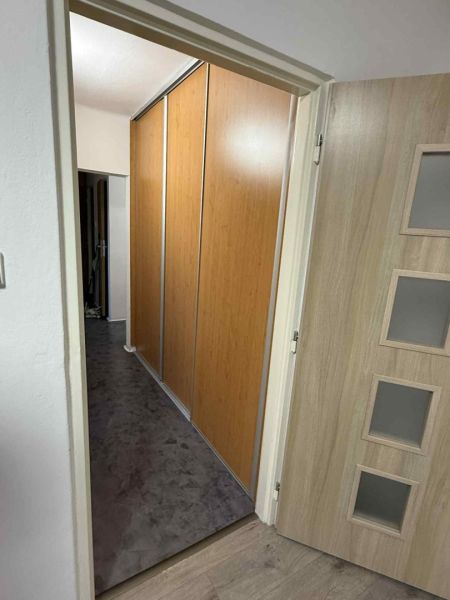 Offene Tür in einer 4-Zimmer-Wohnung mit Holzdekorboden und Einbauschrank.