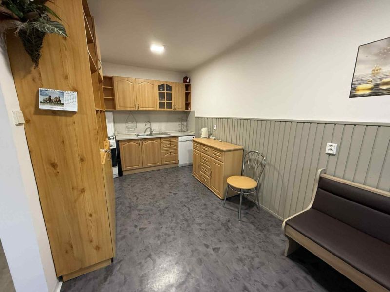 Küche in einer 4-Zimmer-Wohnung mit Holzschränken und einem Boden in Holzoptik.
