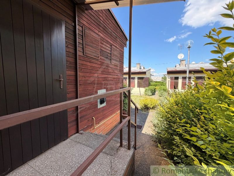 In Nové Zámky, a cottage with a garden, clad in wood, with railings and satellites.