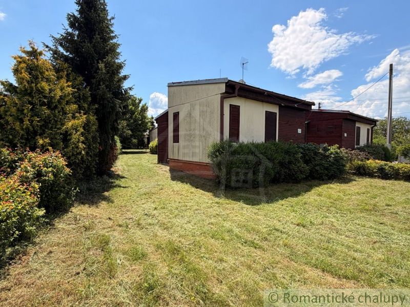 Ein Ferienhaus in Nové Zámky mit Garten und einem Himmel voller Wolken.