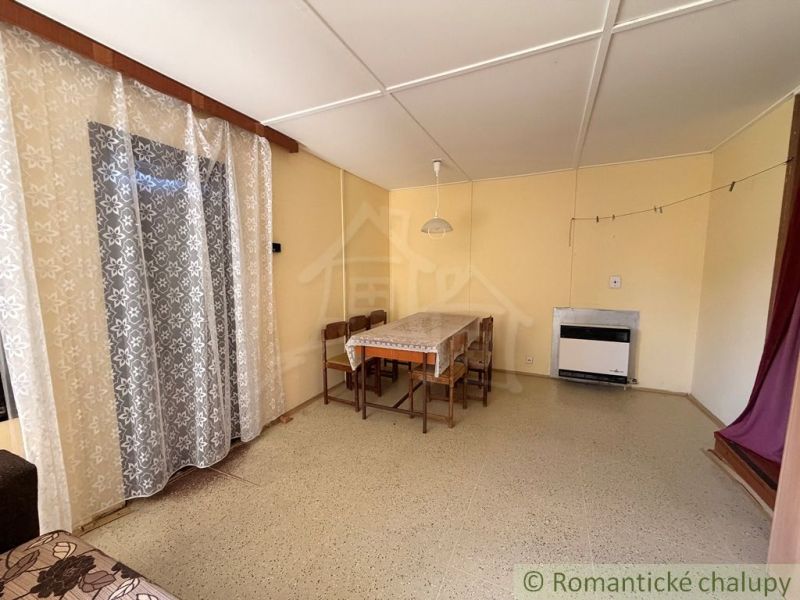 Esszimmer in einer Hütte mit Holzboden und Vorhängen.