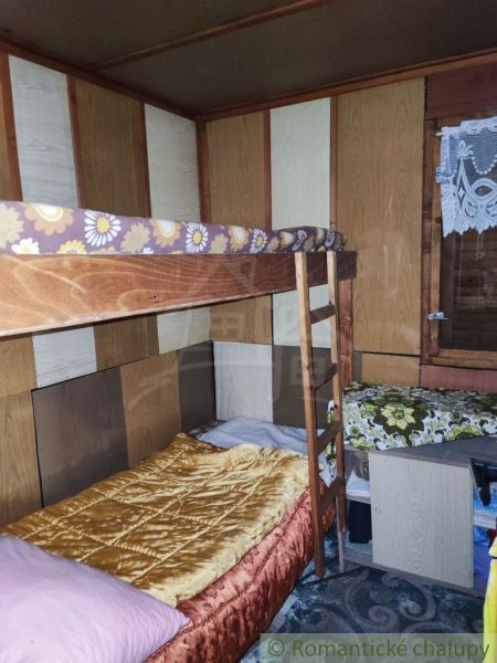 Etagenbett und Holzdekor im Chaletzimmer mit Teppichboden.