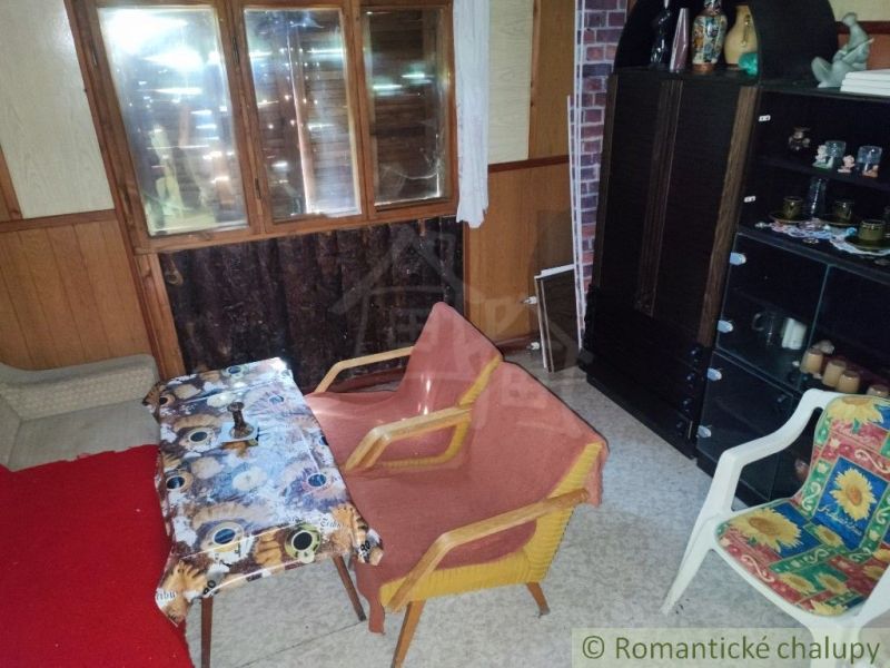 Das Innere der Hütte mit bequemen Stühlen, einem Tisch und einem Schrank für Dekorationsgegenstände.