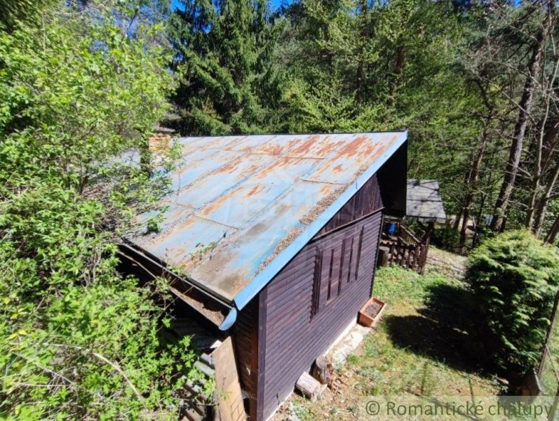 Eine Hütte im Wald bei Slovenská Ľupča, umgeben von Grün und Bäumen.