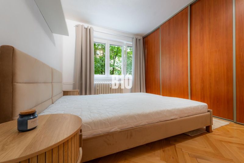 Schlafzimmer in einer 2-Zimmer-Wohnung mit Holzboden und Einbauschrank.
